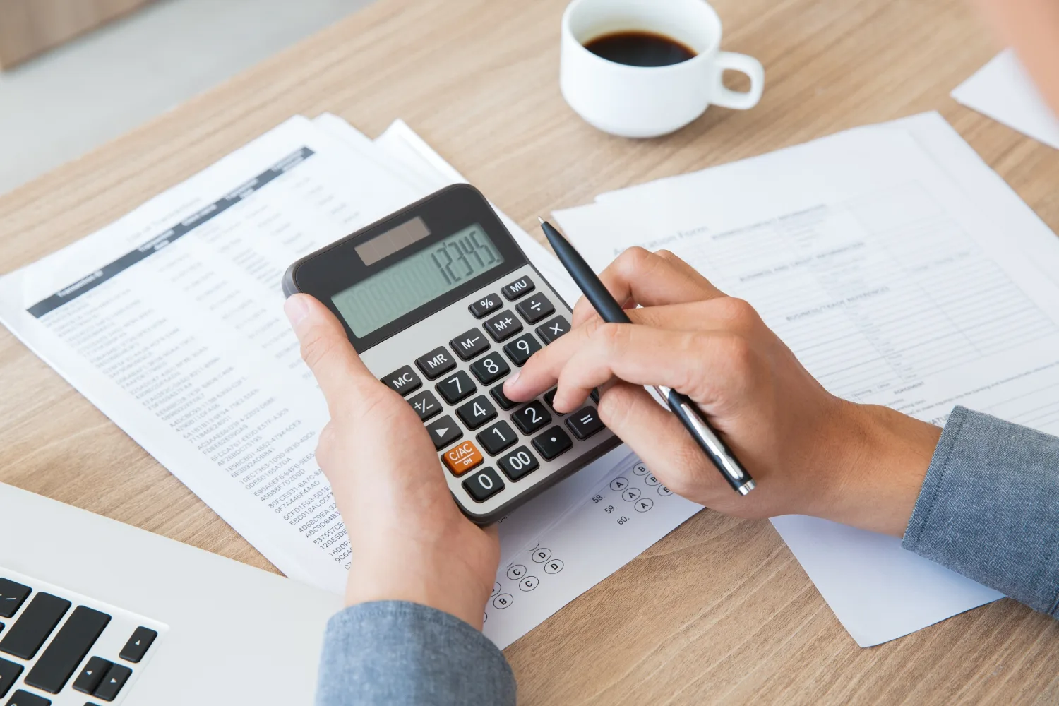 Businessman calculating taxes and social contributions using a calculator