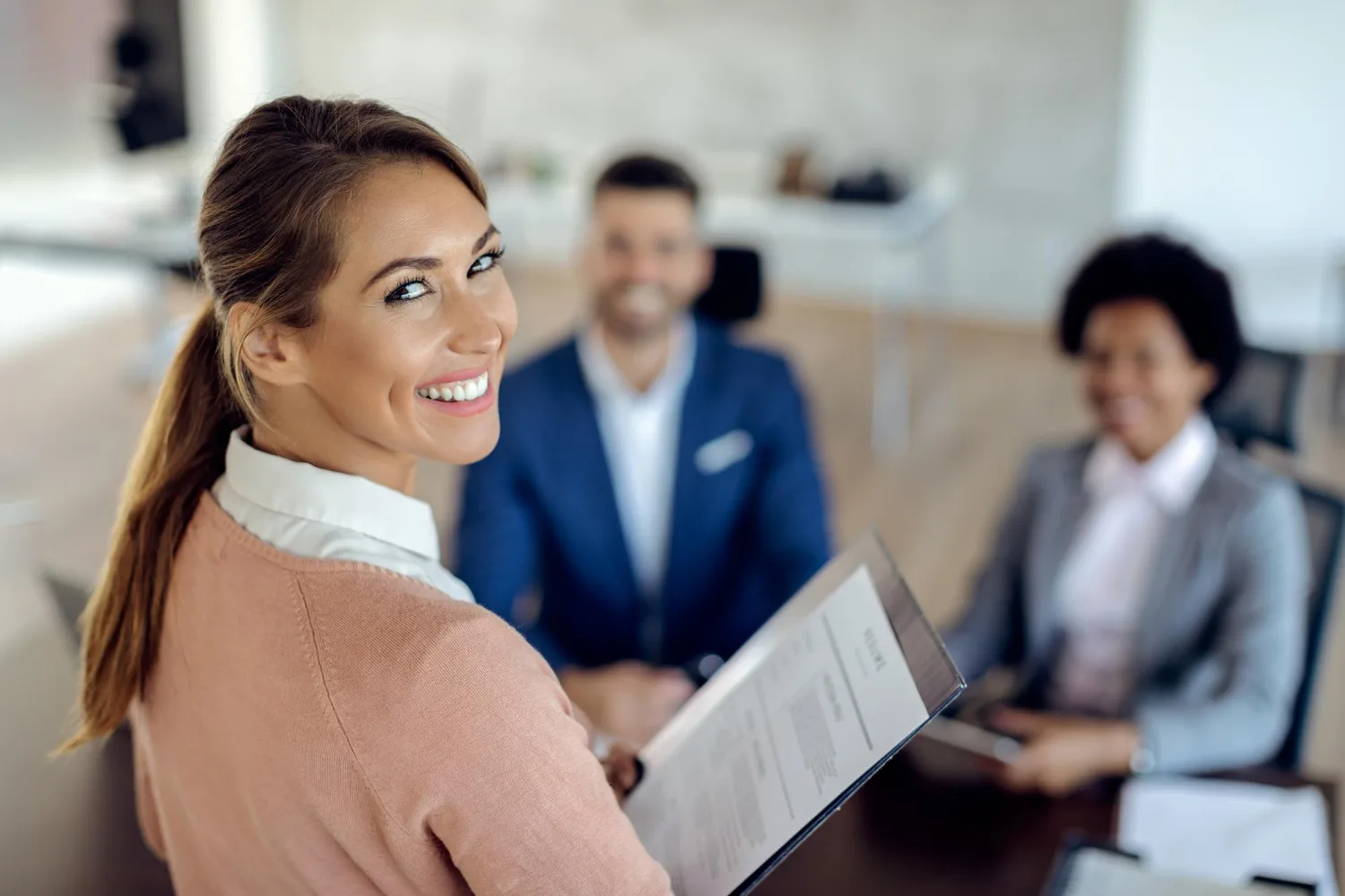 Smiling job applicant holding resume in a panel interview - Customizable Recruitment Pipelines